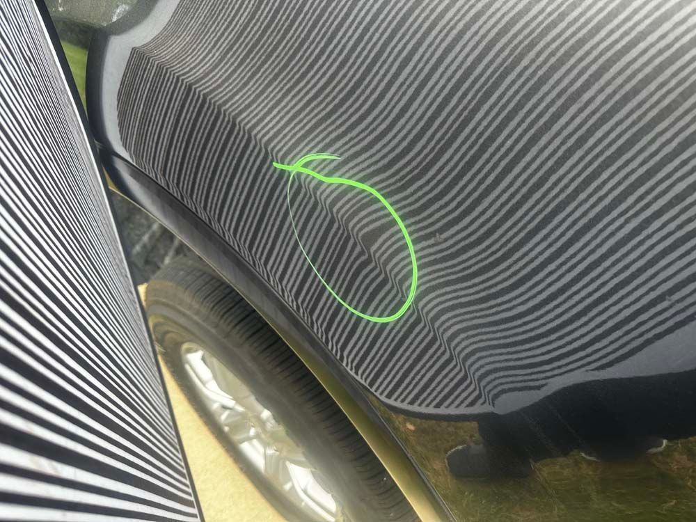 A black car with a green circle on the side of it.