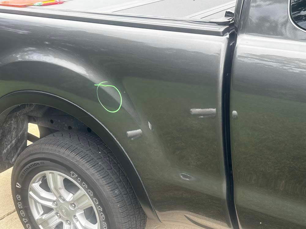 A black truck with a green circle drawn on the side of it.