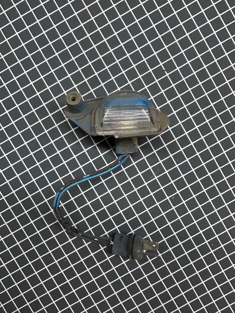 A close up of a license plate light on a checkered surface