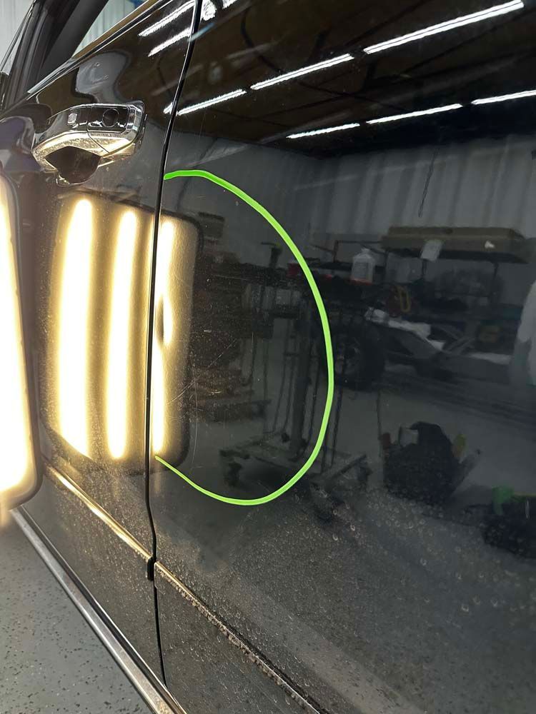 A close up of a car door with a green circle on it.