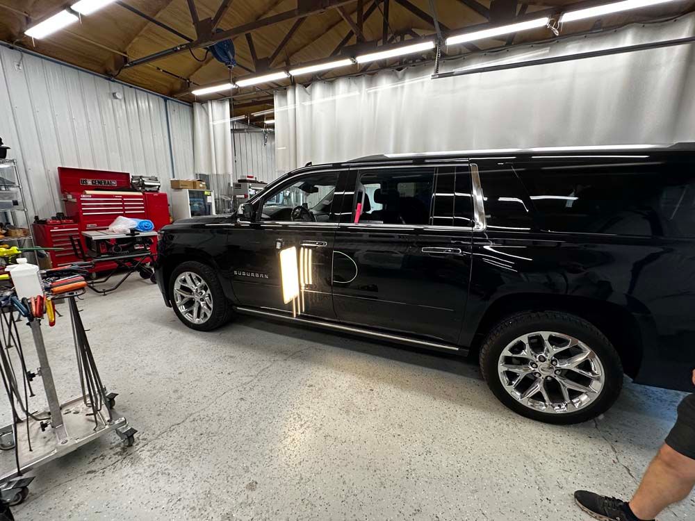 A black suv is parked in a garage.
