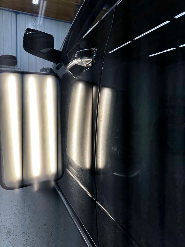 A close up of a car door with a lot of dents on it.