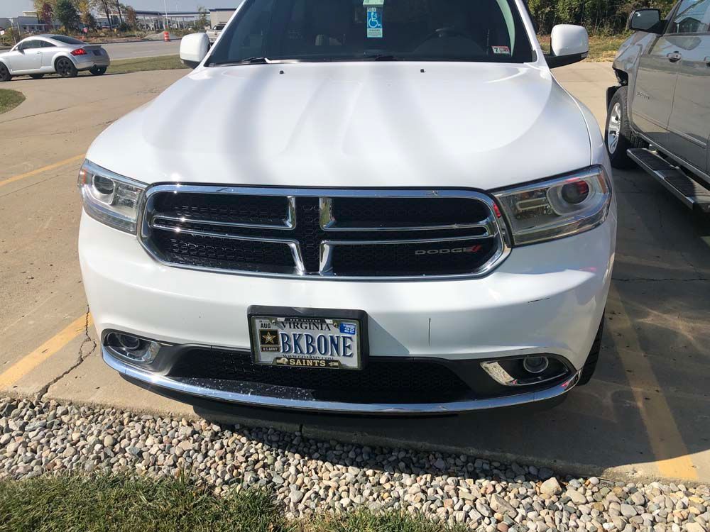 A white dodge durango is parked in a parking lot.