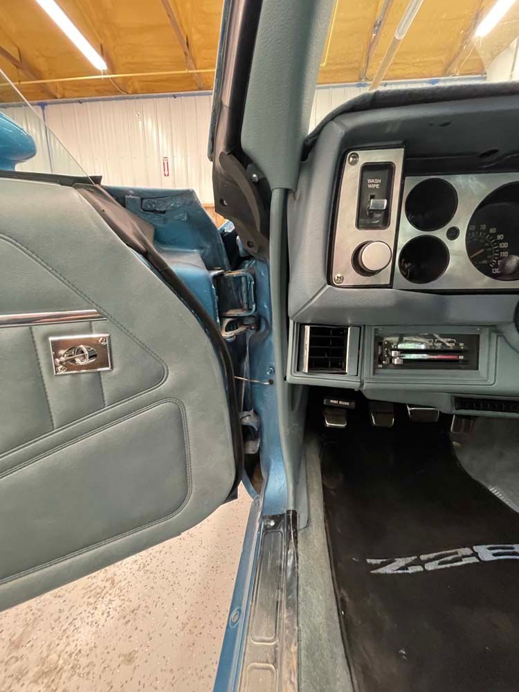 The inside of a blue car with the door open.