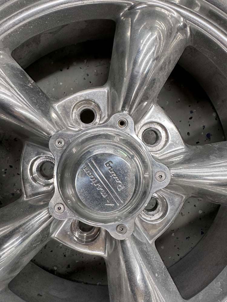 A close up of a wheel with a center cap on it.