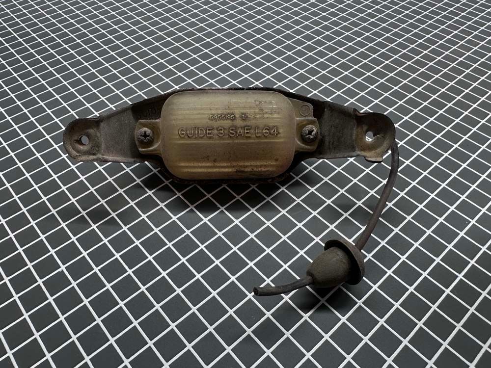 A close up of a metal object on a checkered surface.