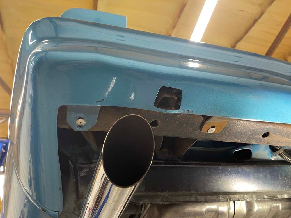 A close up of a blue car with a exhaust pipe