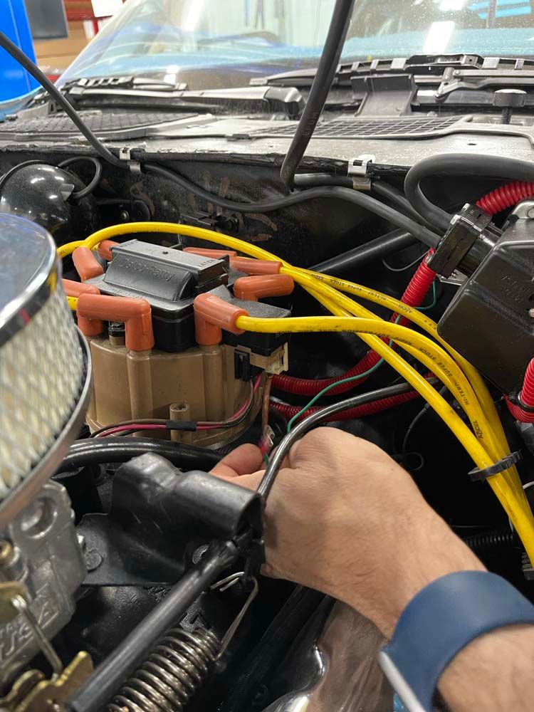 A person is working on the engine of a car.