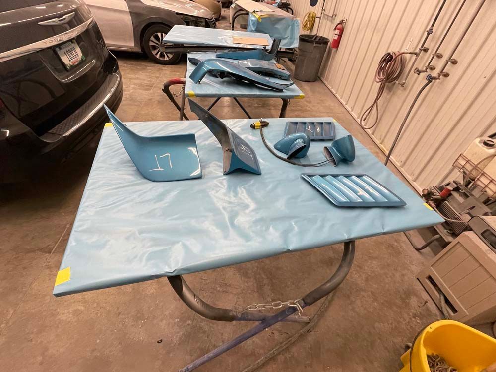 A car is being painted in a garage.