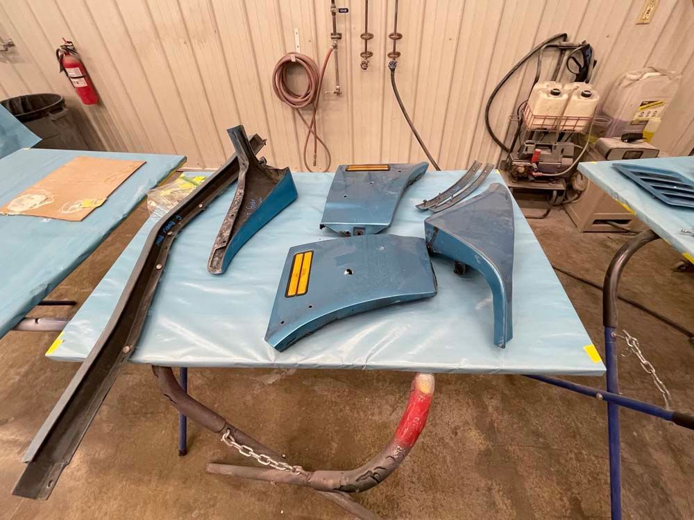 A table with a lot of parts on it in a garage.