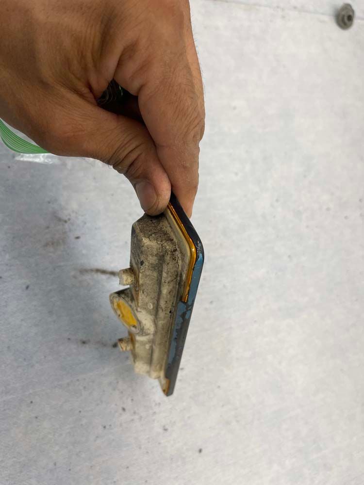 A person is holding a piece of metal in their hand