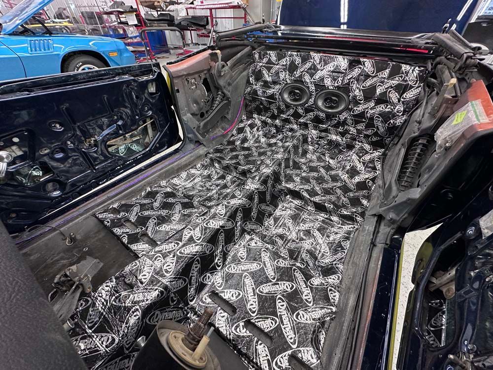 The inside of a car is being worked on in a garage.