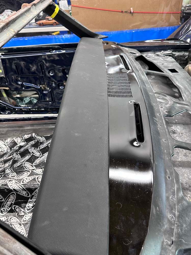A close up of the hood of a car with the hood open.