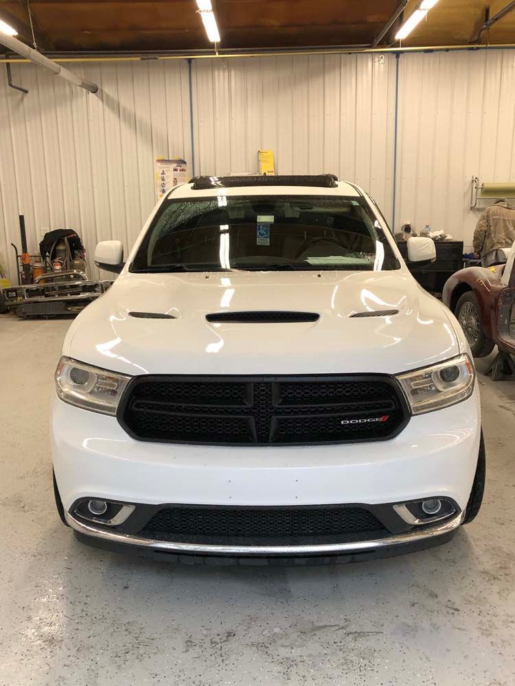 A white dodge durango is parked in a garage.
