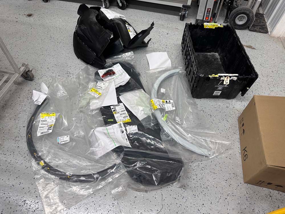 A bunch of plastic bags are laying on the floor in a garage.