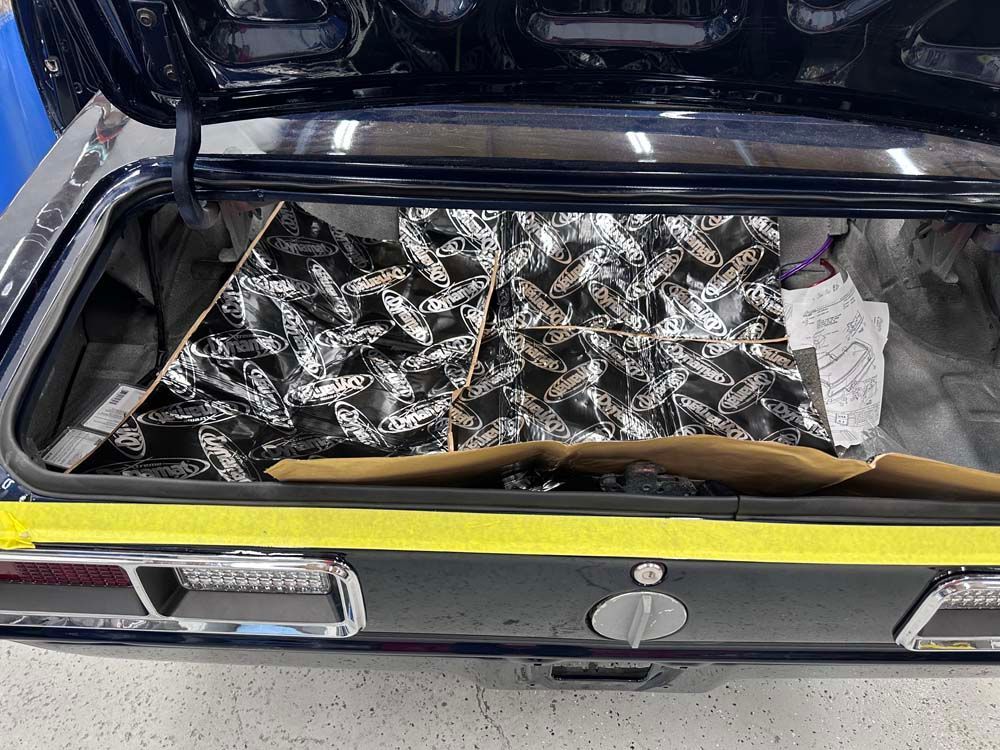 The trunk of a car with a piece of aluminum foil in it.