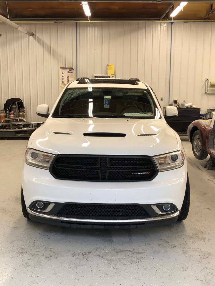 A white dodge durango is parked in a garage.