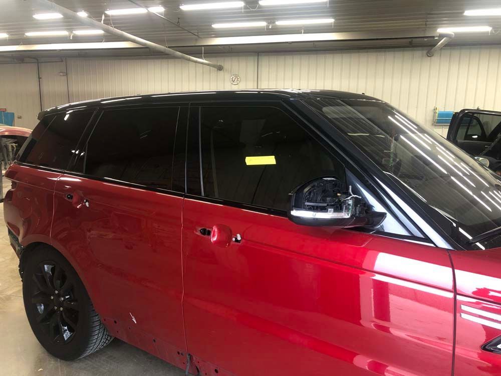 A red range rover sport is parked in a garage.
