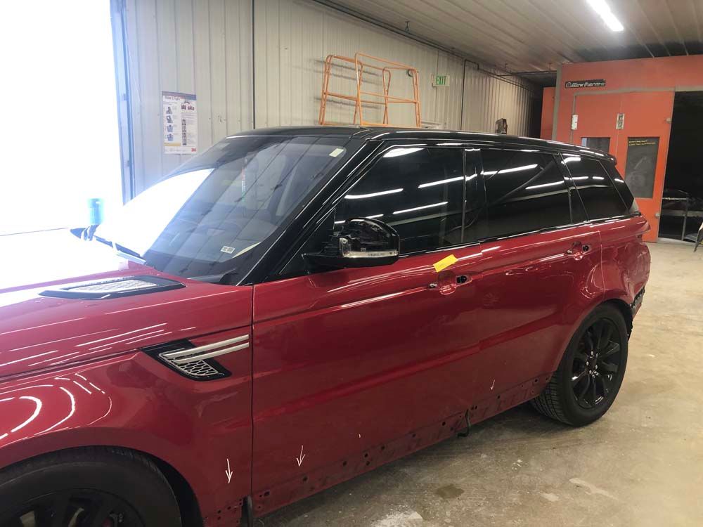 A red range rover sport is parked in a garage.