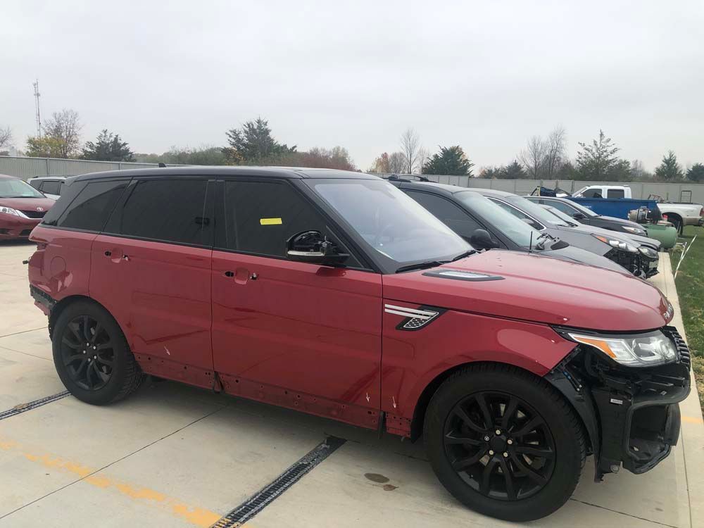 A red range rover sport is parked in a parking lot.