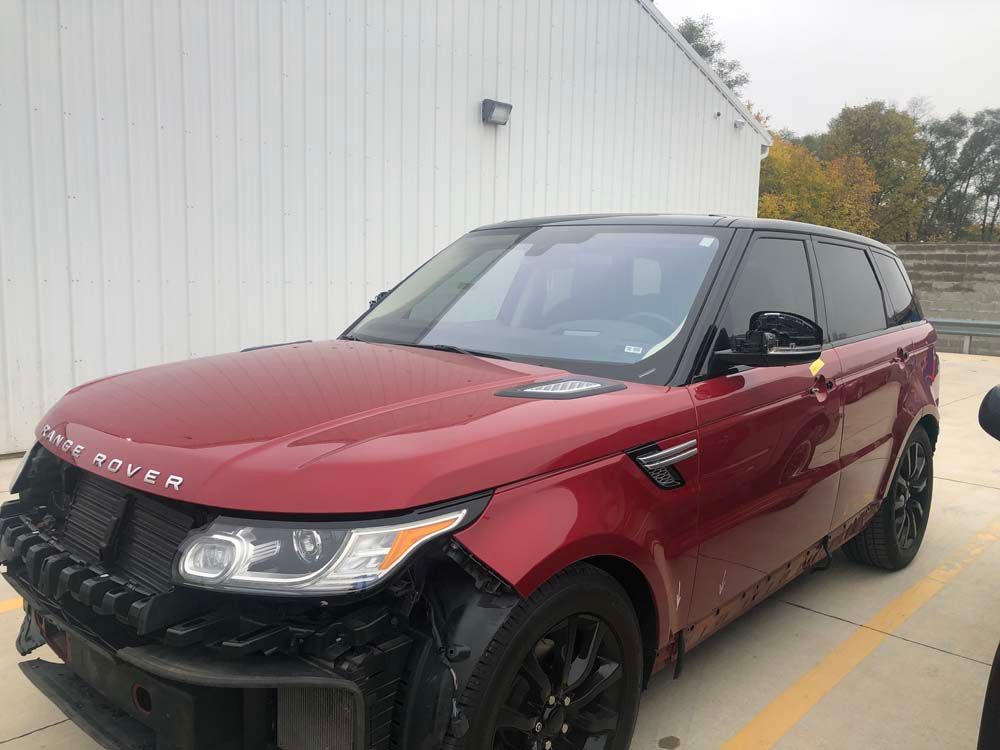 A red range rover sport is parked in a parking lot.