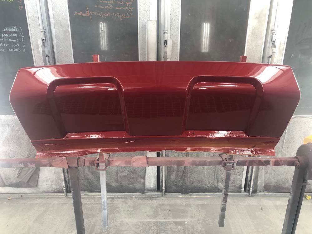 A red piece of metal is sitting on top of a metal stand.