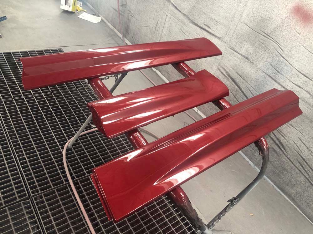 A red bench is sitting on top of a metal grate