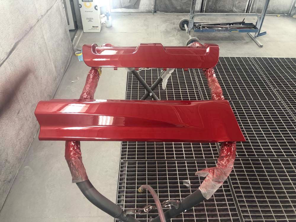 A red piece of metal is sitting on top of a metal grate.