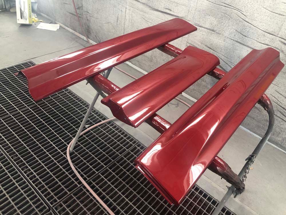 A red bench is sitting on top of a metal grate.