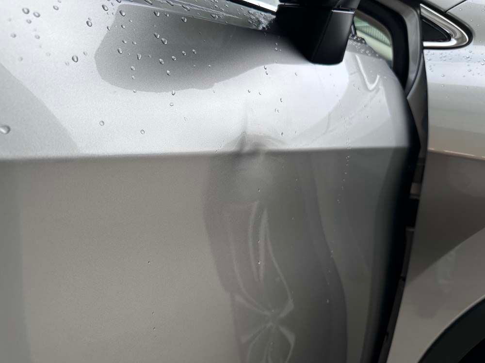 A close up of a car with a damaged fender.