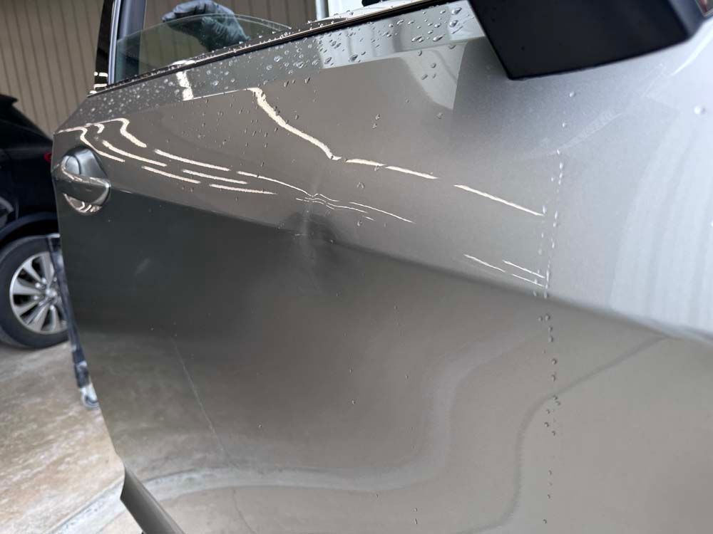 A close up of a car door in a garage.