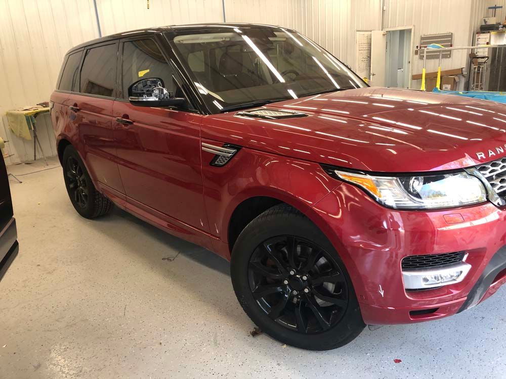 A red range rover sport is parked in a garage.