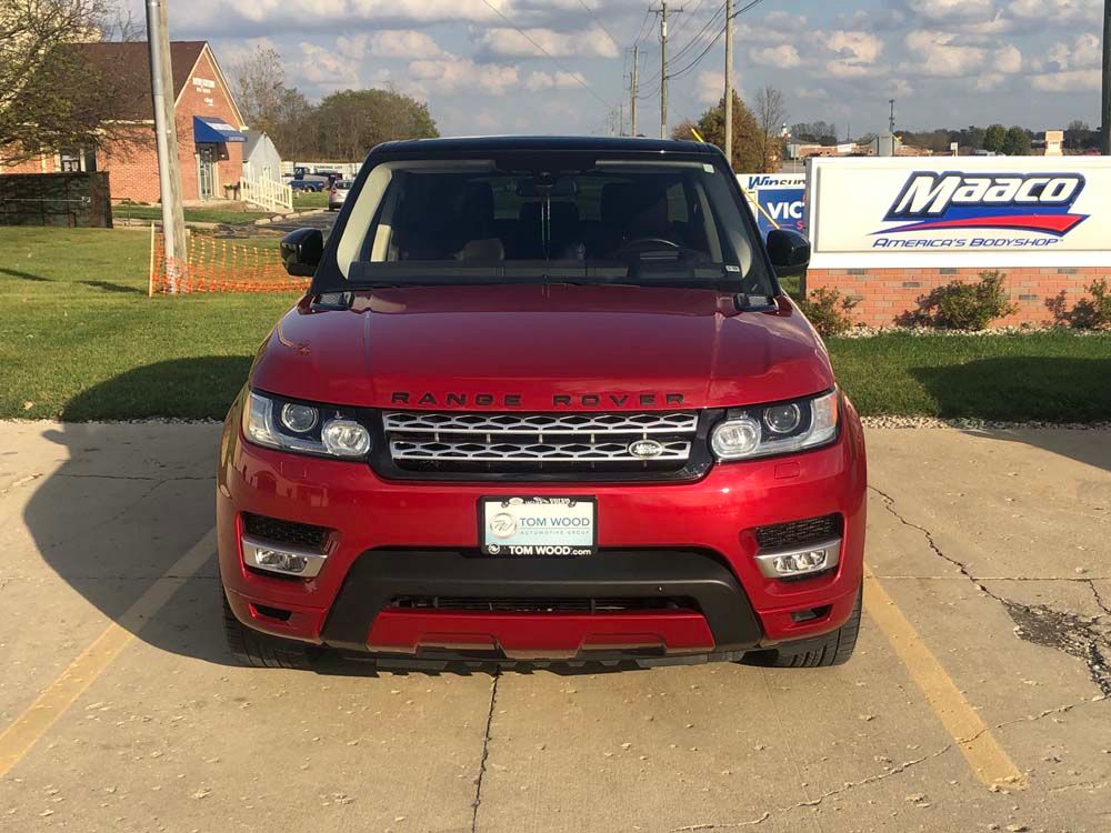 A red range rover sport is parked in a parking lot.
