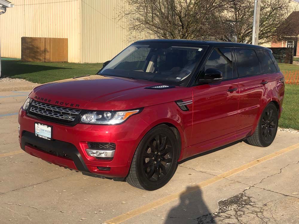 A red range rover sport is parked in a parking lot.
