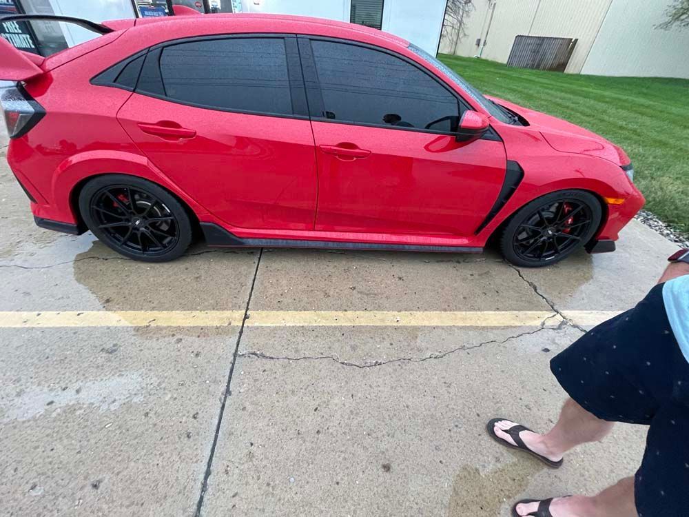 A red honda civic type r is parked in a parking lot.