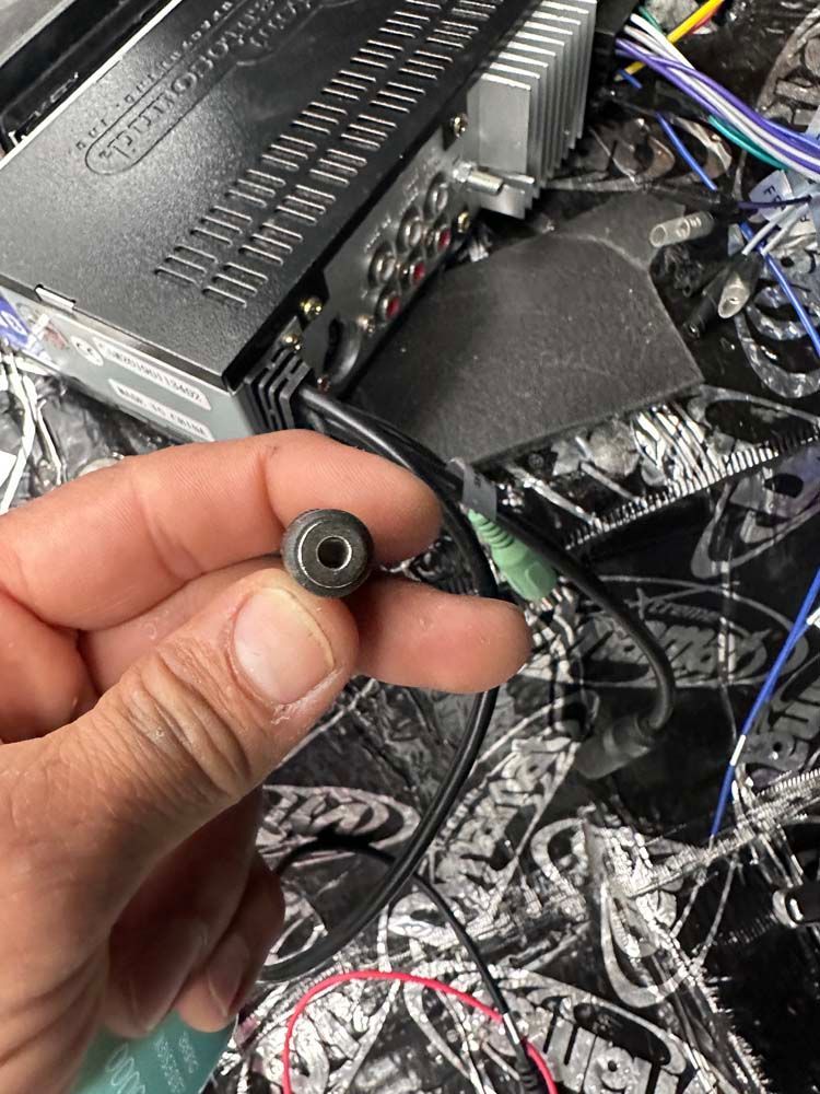 A person is holding a small black object in their hand.