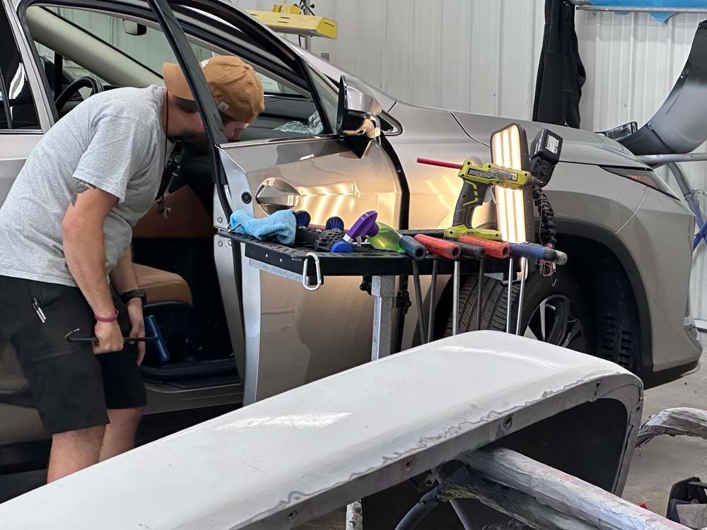 A man is working on a car in a garage.