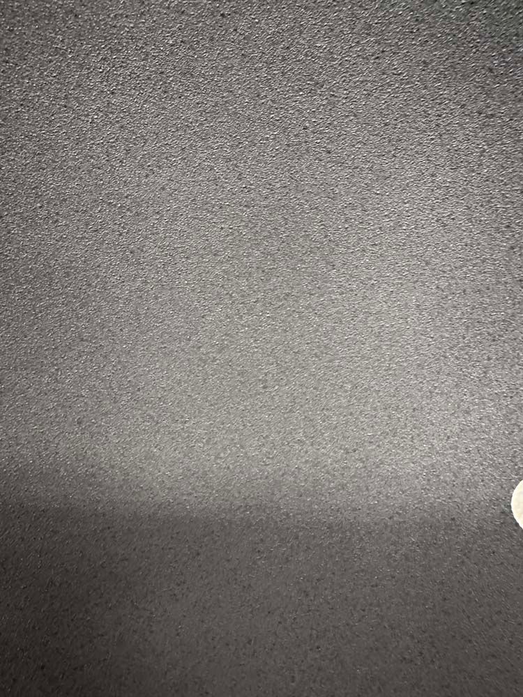 A close up of a gray surface with a light shining on it.