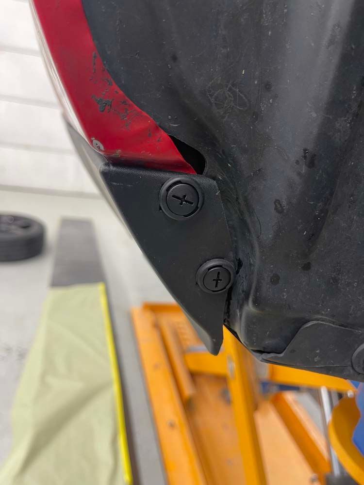 A close up of a fender with screws on it.