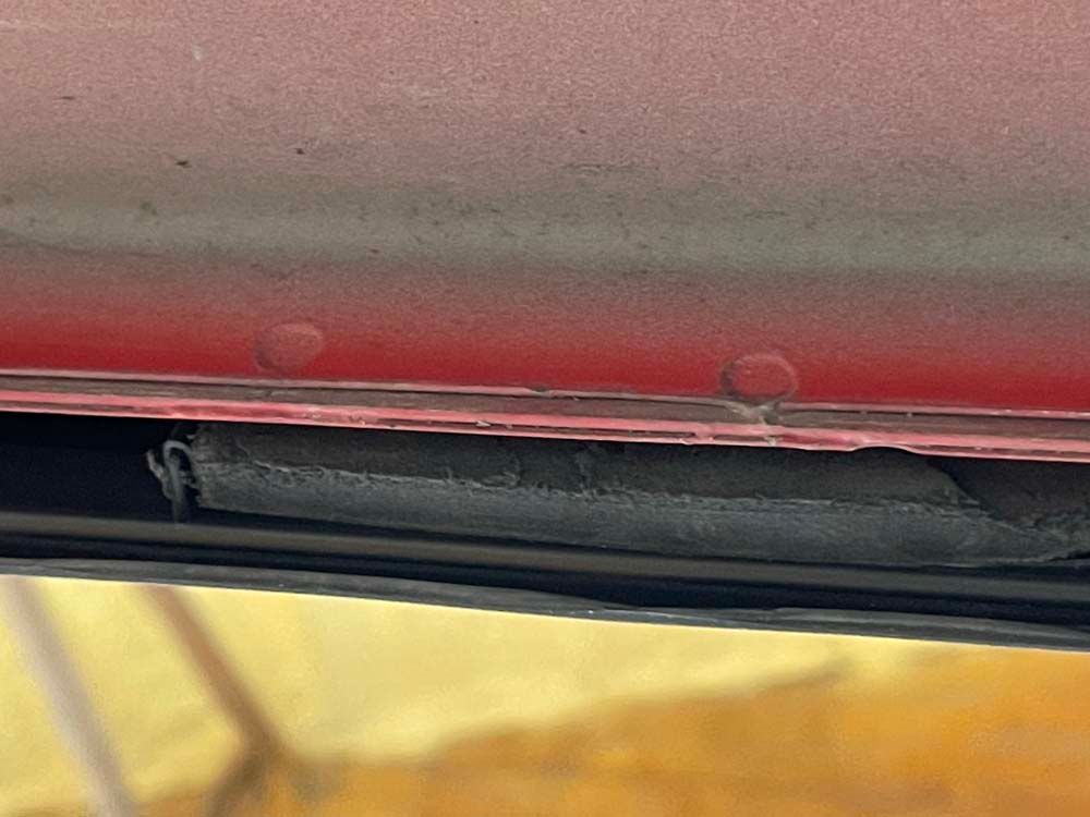 A close up of the underside of a red car.