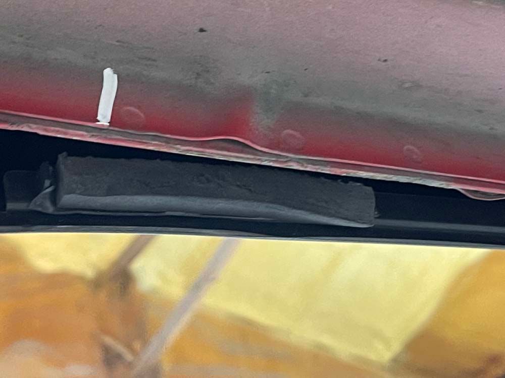 A close up of the underside of a red car.