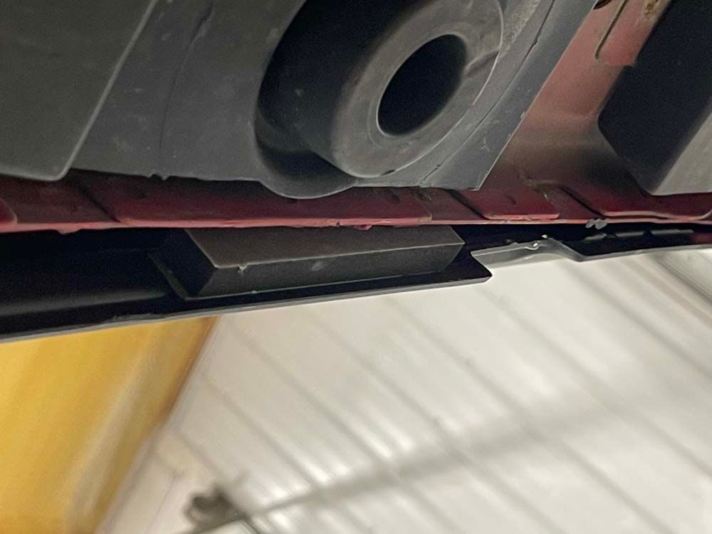 A close up of the underside of a car in a garage.