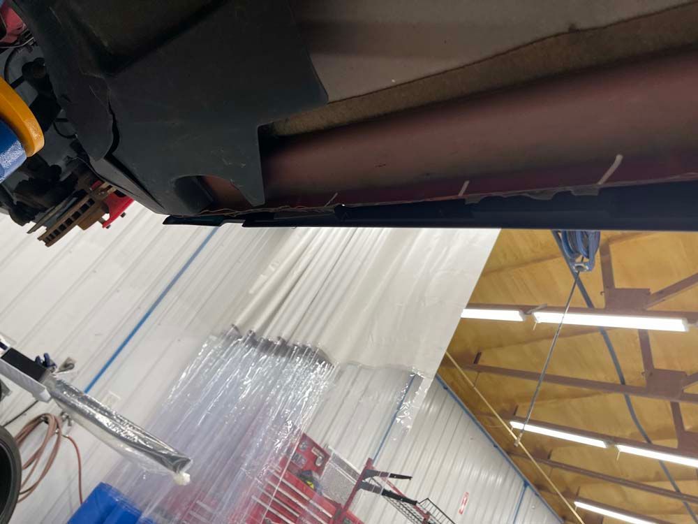 A car is sitting under a lift in a garage