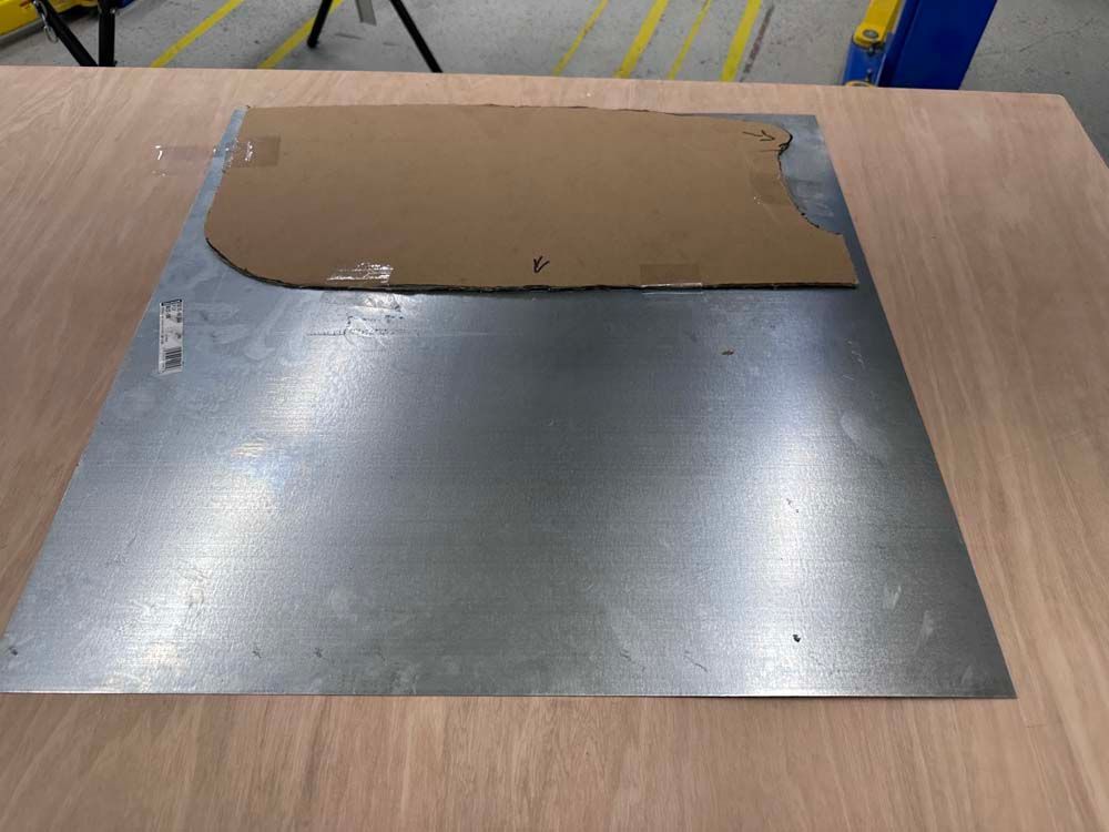 A piece of metal is sitting on top of a wooden table