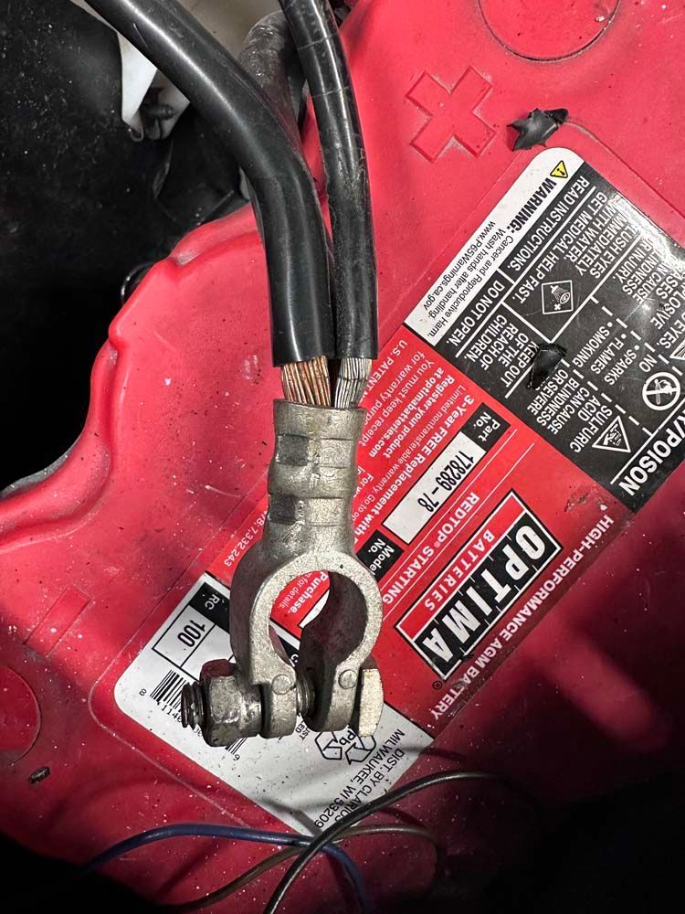 A red optima battery with a black cable attached to it