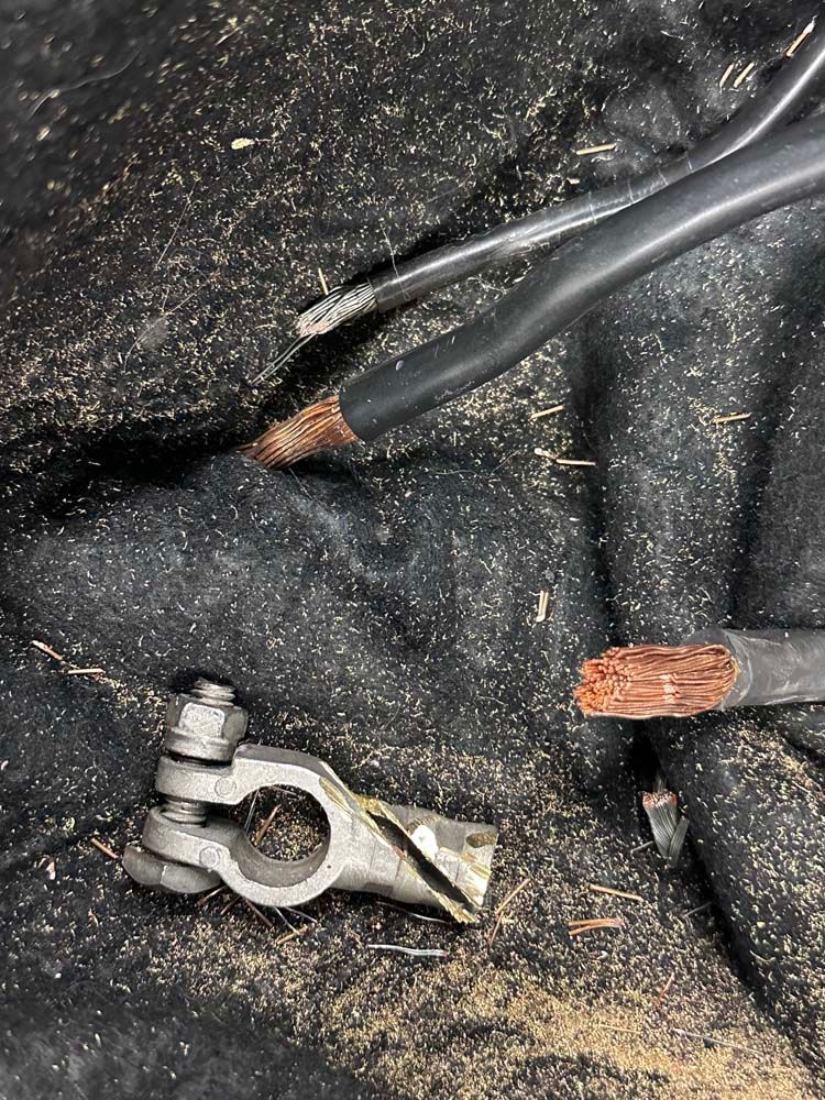 A close up of a battery terminal with two wires coming out of it.