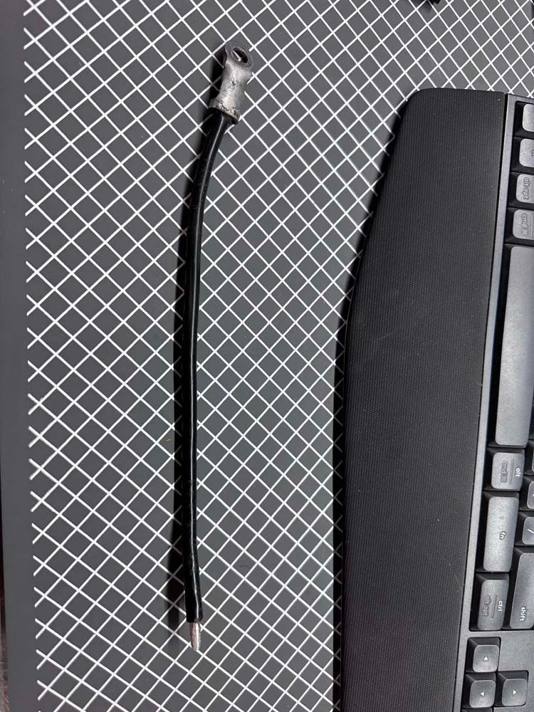 A pen is sitting on a black and white checkered mat next to a keyboard.