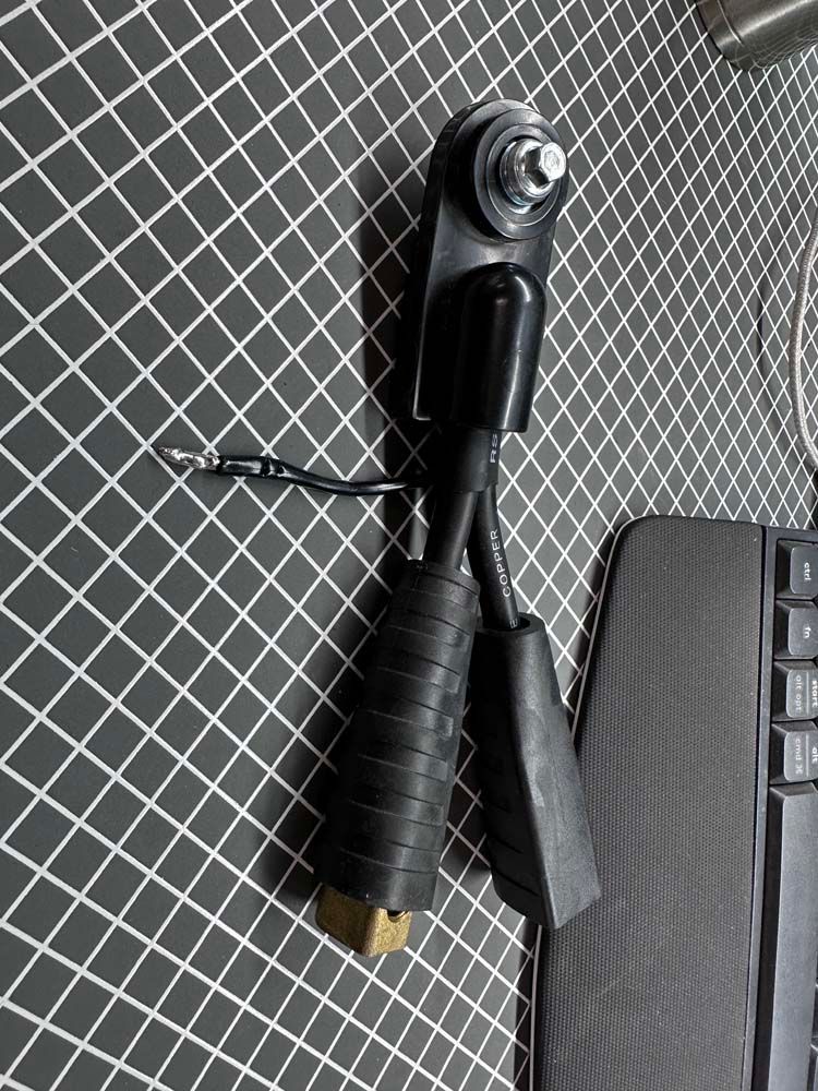 A black object is sitting on a checkered table next to a keyboard.