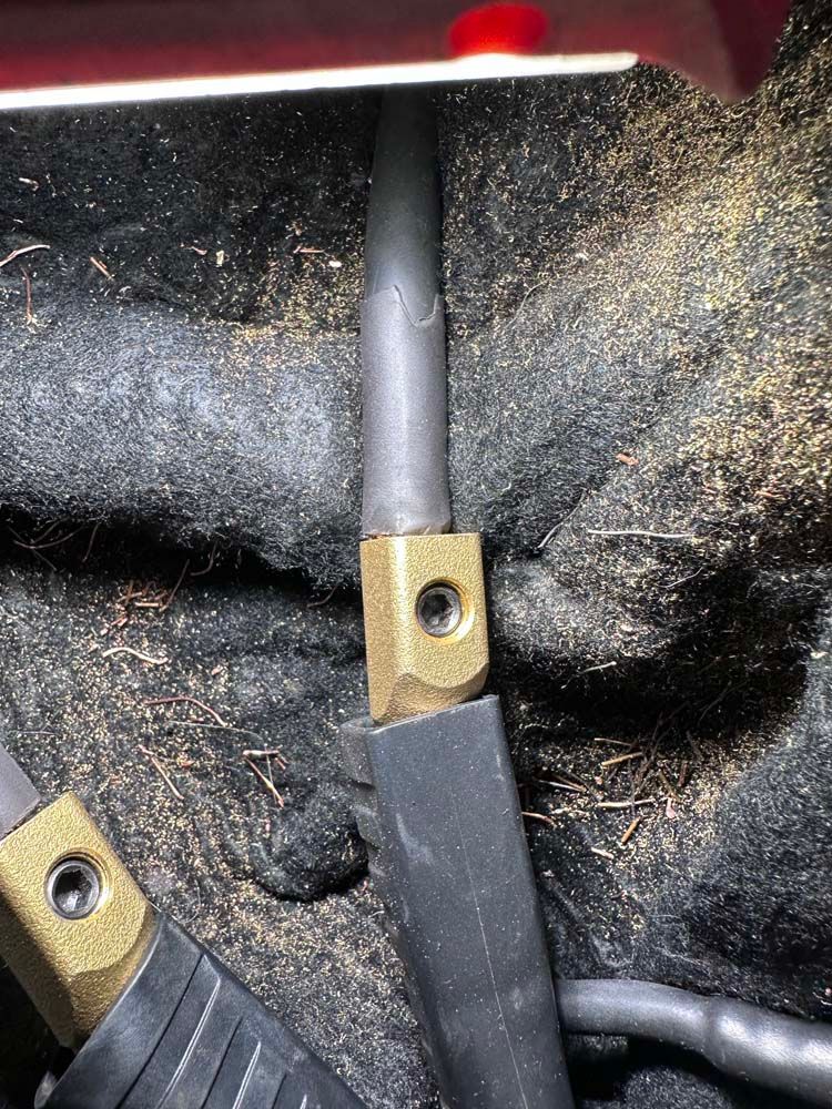 A close up of a welding cable with a hole in it.