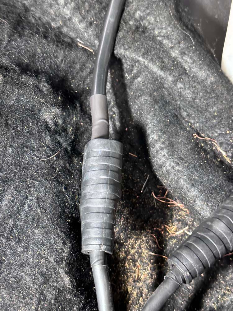 A close up of a black cable on a black surface.